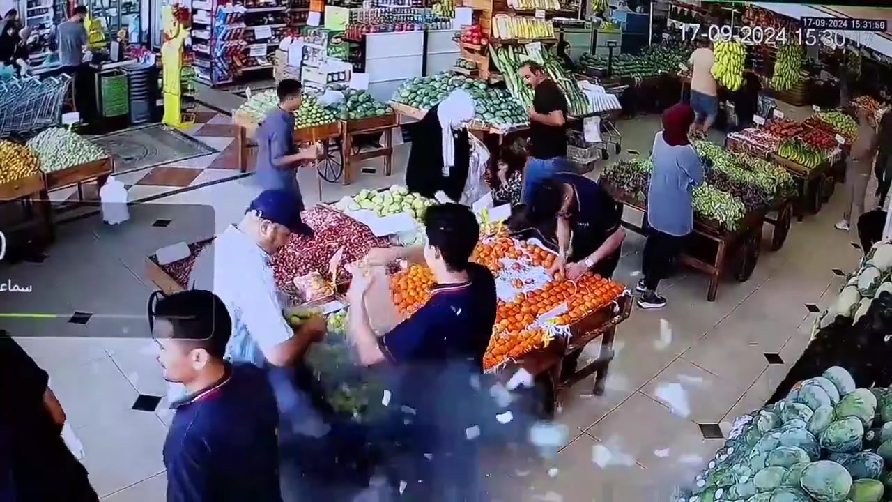 A burst of smoke and debris beside shoppers in a Beirut market, captured by CCTV on September 17, 2024.