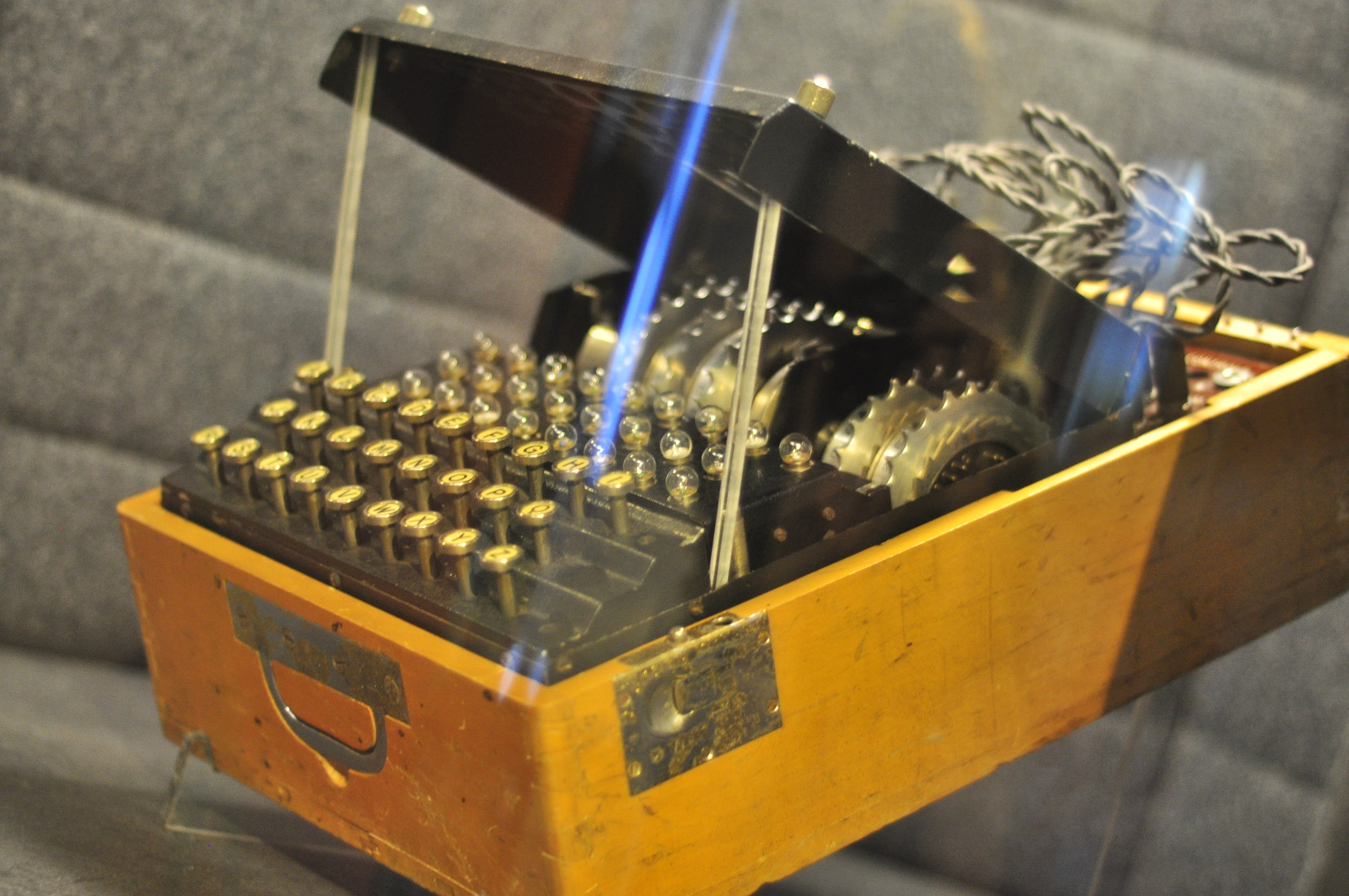 A Polish-built Enigma replica with black keys and exposed rotors in a wooden case