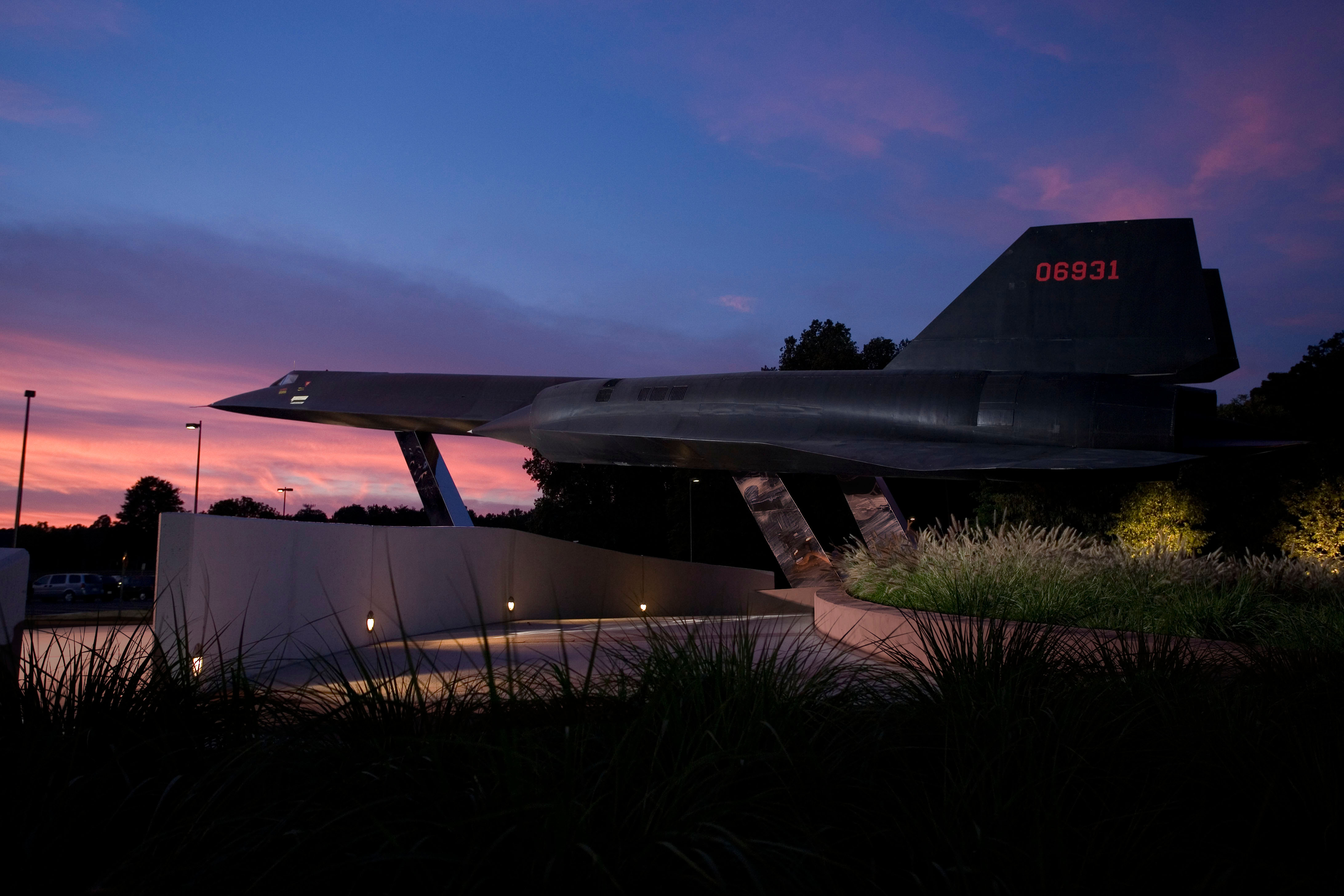 A black A-12 OXCART displayed against a vivid sunset, showing the long pointed nose and engine nacelles