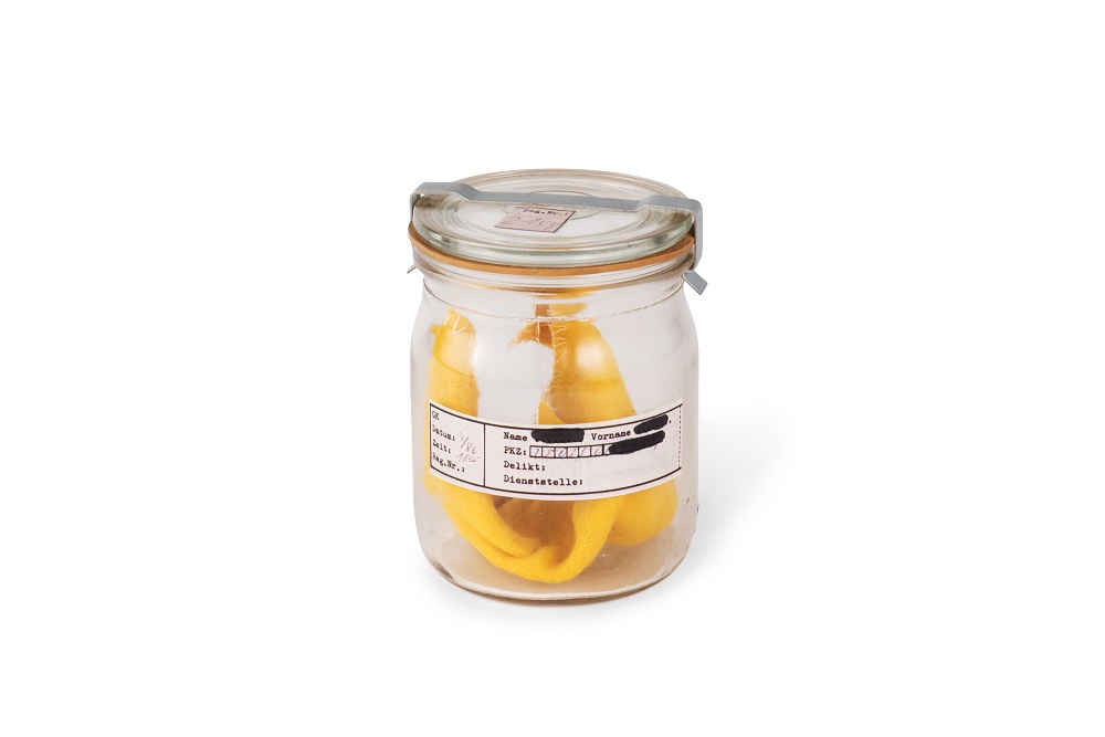 A labelled Stasi scent jar containing a folded yellow cloth